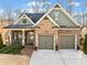 Charming home with brick and stone accents, covered porch, two-car garage, and landscaped front yard at 1545 Camden Cove Dr, Cumming, GA 30040