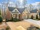 Traditional brick home with two-car garage, covered porch, and manicured lawn at 1545 Camden Cove Dr, Cumming, GA 30040