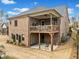 Two story brick home featuring a back balcony, covered patio, and manicured lawn at 1545 Camden Cove Dr, Cumming, GA 30040
