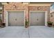 Two-car garage featuring carriage-style doors and stone accents, enhancing the home's curb appeal at 1545 Camden Cove Dr, Cumming, GA 30040