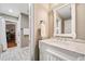 Powder room featuring a marble countertop, white cabinetry, and decorative mirror at 1545 Camden Cove Dr, Cumming, GA 30040