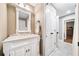 Powder room featuring a marble countertop, white cabinetry, and decorative mirror at 1545 Camden Cove Dr, Cumming, GA 30040