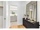Hallway with rich wood floors leads to a stylish bathroom, accentuated by a decorative mirror and chest at 2575 Peachtree Ne Rd # 6G, Atlanta, GA 30305