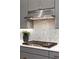 Gas cooktop with stainless steel vent hood and white quartz countertop at 3018 Eamont Ter, Atlanta, GA 30328