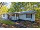 White ranch home with a covered porch and garden at 1355 Woodland Sw Dr, Oxford, GA 30054