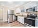 Modern kitchen featuring stainless steel appliances, granite countertops, and white cabinetry at 2318 Ousley Ct, Decatur, GA 30032
