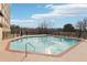 Outdoor pool surrounded by a black fence and trees, with a clear blue sky reflected in the water at 2479 Peachtree Ne Rd # 1012, Atlanta, GA 30305
