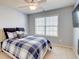 Bright bedroom includes a ceiling fan, a large window, and a plaid comforter at 3120 Esplanade Sw Cir, Atlanta, GA 30311