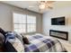 Inviting bedroom featuring a fireplace, mounted TV, and a window with natural light at 3120 Esplanade Sw Cir, Atlanta, GA 30311