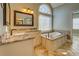 Bathroom with a soaking tub, granite countertops and a large window with an arch at 45 Kinloch Ct, Covington, GA 30014
