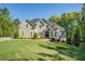 Two-story home with manicured lawn, beautiful landscape, and a front-facing three car garage at 45 Kinloch Ct, Covington, GA 30014