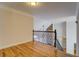 Upstairs hallway boasts hardwood floors and iron railing, offering a glimpse of the living room below at 45 Kinloch Ct, Covington, GA 30014