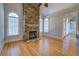 Cozy living room featuring a stone fireplace, hardwood floors and large windows at 45 Kinloch Ct, Covington, GA 30014