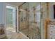 Luxurious walk-in shower with a glass door and stylish tile design, featuring stone flooring at 45 Kinloch Ct, Covington, GA 30014