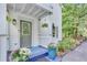 Charming front porch with decorative columns, hanging plants, and a cozy blue welcome mat at 8535 Lynn Dr, Cumming, GA 30041