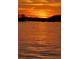 Beautiful sunset over the water with golden and orange tones, casting a warm glow on the water's surface at 8535 Lynn Dr, Cumming, GA 30041