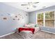 Cozy bedroom featuring a twin bed, whimsical car decals, a ceiling fan and natural light from a large window at 1114 Ivey Chase Pl, Dacula, GA 30019