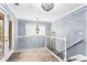 Bright hallway with white railings, neutral carpet, and natural light from glass doors at 1114 Ivey Chase Pl, Dacula, GA 30019