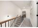 Hallway featuring wooden stairs, black railing, and natural light at 24 Jacobs Farm Ln # 12, Lawrenceville, GA 30045