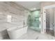 Bright bathroom featuring a glass shower, soaking tub, and marble tile at 2715 Memorial Se Dr, Atlanta, GA 30317