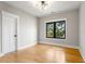 Bedroom with hardwood floors, modern lighting, and windows with outdoor view at 2715 Memorial Se Dr, Atlanta, GA 30317