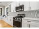 White kitchen with stainless steel appliances, backsplash, and a window seat at 2715 Memorial Se Dr, Atlanta, GA 30317