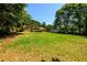 Expansive backyard with lush green grass and mature trees offering shade and privacy at 780 Navajo Trl, Covington, GA 30016