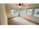 Bright bedroom featuring three large windows with plush carpeting and a ceiling fan at 780 Navajo Trl, Covington, GA 30016