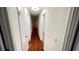 Hallway with wood flooring and access to various rooms at 780 Navajo Trl, Covington, GA 30016