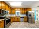 Kitchen with wood cabinets and stainless steel appliances at 780 Navajo Trl, Covington, GA 30016