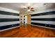 Living room with hardwood floors, ceiling fan, and a stylish accent wall at 780 Navajo Trl, Covington, GA 30016