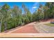 Sloped backyard with lush trees and red clay at 105 Eryn Ter, Covington, GA 30014