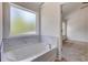 Relaxing bathroom with soaking tub and marble tile accents at 105 Eryn Ter, Covington, GA 30014