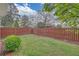 Fenced backyard featuring a well-manicured lawn, wood fence, and mature trees at 1125 Blackshear Dr, Decatur, GA 30033