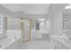 Spacious bathroom with double sinks, soaking tub, glass enclosed shower and white tile at 1125 Blackshear Dr, Decatur, GA 30033