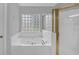 Bright bathroom featuring a luxurious tub with jets and a glass block window for natural light at 1125 Blackshear Dr, Decatur, GA 30033