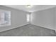 Well lit bedroom featuring neutral carpeting, windows with blinds, and light gray walls at 1125 Blackshear Dr, Decatur, GA 30033