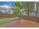 Patio with brick tiles in fenced backyard with lawn and trees in the background at 1125 Blackshear Dr, Decatur, GA 30033