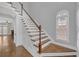 Elegant staircase with wooden handrail, white risers, and natural light from a window at 1125 Blackshear Dr, Decatur, GA 30033