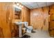 Vintage bathroom with wood paneled walls, updated fixtures, and pedestal sink at 380 Stone Rd, Mcdonough, GA 30253