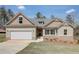 New single-story home with a two-car garage, landscaping, and a light beige exterior at 215 Eryn Ter, Covington, GA 30014