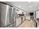 Galley kitchen featuring stainless steel appliances, white cabinets and access to the living room at 650 Hunterhill Ct, Roswell, GA 30075