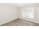 A bright bedroom featuring modern gray plank flooring and ample natural light from the large double window at 20 Oak Wood Ln, Covington, GA 30016