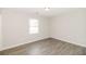 A bright bedroom featuring modern gray plank flooring and ample natural light from the large window at 20 Oak Wood Ln, Covington, GA 30016