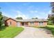 Charming single-story brick home with a well-manicured lawn and a concrete driveway under a bright blue sky at 20 Oak Wood Ln, Covington, GA 30016