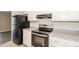 Well-equipped kitchen features white cabinets, stainless steel appliances, granite countertops, and tile flooring at 20 Oak Wood Ln, Covington, GA 30016