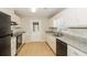 Modern kitchen boasts white cabinets, granite countertops, stainless steel appliances, and tile flooring at 20 Oak Wood Ln, Covington, GA 30016