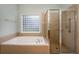 Bathroom with tub, shower, and block window at 305 Mogie Ln, Acworth, GA 30102