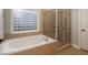 Bathroom features a shower, garden tub, and a block window at 305 Mogie Ln, Acworth, GA 30102