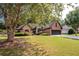 Brick and stone house with a large tree and landscaped yard at 305 Mogie Ln, Acworth, GA 30102